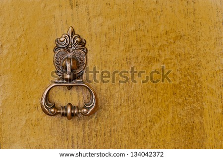 Vintage bronze handle on a wooden door
