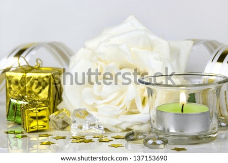 white rose, gift boxes and green burning candle