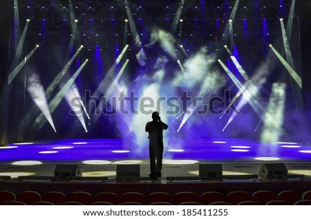 singing man silhouette on a brightly lit concert stage