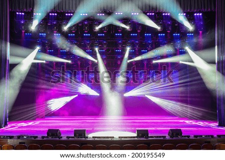 Illuminated empty theater stage with smoke and rays of light