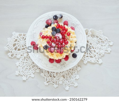 Decorative plate with sweet waffles and fresh berries, powdered with sugar