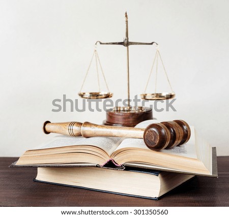 Symbols of law: wood gavel, soundblock, scales and opened volumetric old books