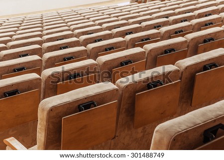 Rows of beige velvet armchairs in the auditorium