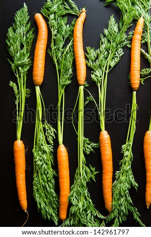 Fresh carrots on a black wooden table