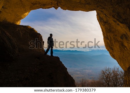 beautiful  man  in  mainsail  and cave in the mountains