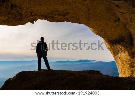 beautiful  man  in  mainsail  and cave in the mountains