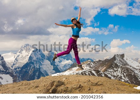 woman jump on top of a beautiful mountain