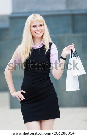 portrait  beautiful blonde woman with pack shopping city background