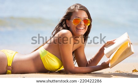 beautiful fun and joy brunette woman in yellow bikini reading a book  tropical  blue sea water has sports and tan body