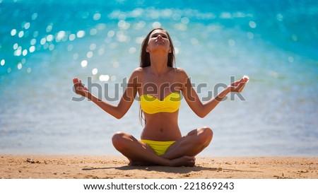 beautiful  brunette woman in yellow bikini posing  meditation yoga in tropical  blue sea water has sports and tan body