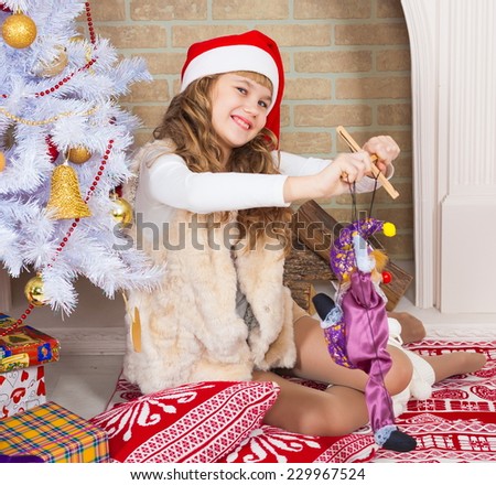 beautiful  smiling  little blonde girl near the christmas tree with tree toy