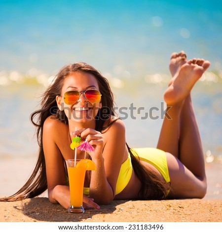 beautiful fun and joy brunette smiling woman in yellow bikini drink orange cocktail in  tropical  blue sea water has sports and tan body