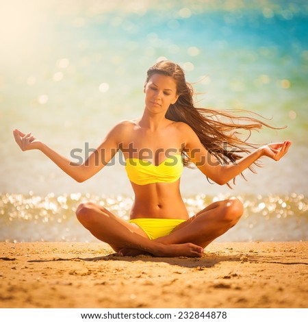 beautiful  brunette woman in yellow bikini posing  meditation yoga in tropical  blue sea water has sports and tan body