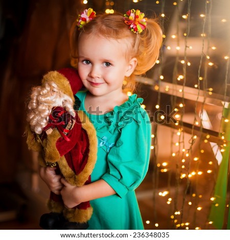 beautiful  smiling  little blonde girl  with  soft toy on christmas  lights background