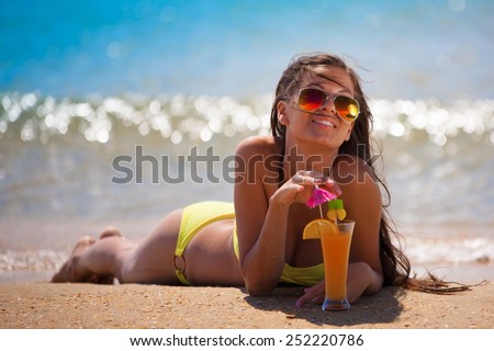 beautiful fun joy brunette smiling lady woman yellow bikini drink orange cocktail tropical blue sea water bali sports tan body cream adventure sunscreen close up sunbathing amazing