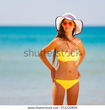 beautiful fun and joy brunette lady woman in yellow bikini posing  tropical  blue sea water \
bali has sports and tan body