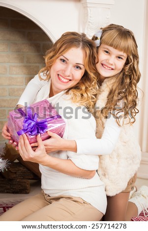 beautiful  smiling  blonde  mother and daughter tree with gifts, mother\'s Day, March 8