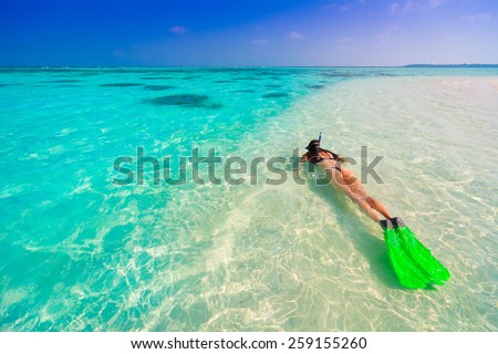 landscape beautiful women in bikini  with flippers, mask and tube snorkeling on romantic  atoll island paradise luxury  resort about coral reef