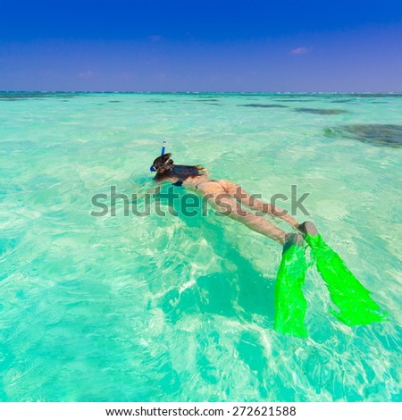 beautiful women in bikini  with flippers, mask and tube snorkeling on romantic  atoll island paradise luxury  resort about coral reef