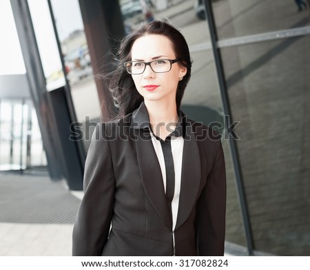 Beautiful sensuality elegance lady brunette woman, has happy face, black business suit, glasses, slim body. Urban city portrait. Nature lifestyle.