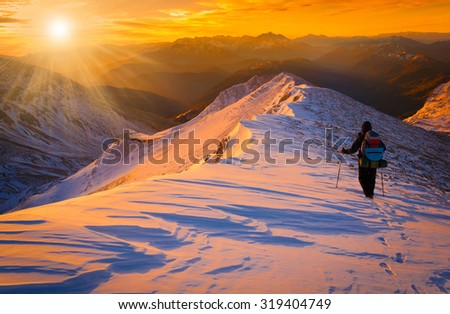Beautiful amazing sunset winter mountains.  A man goes a sport hike in snow holidays. Christmas background. Unique landscape. Northern country Russia Caucasus.