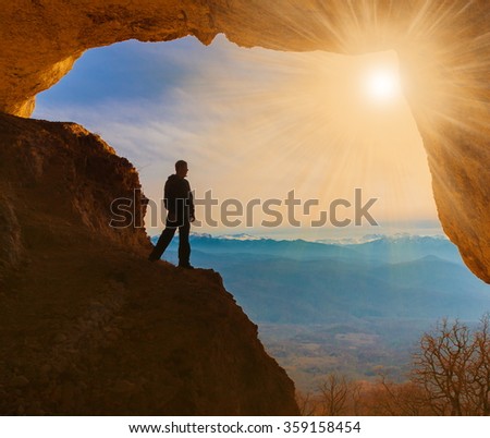 Beautiful amazing sunset.  Mountains in north country Russia Caucasus. Unique landscape mainsail.  Silhouette of a man. Old cave. Active sport and hobby. Spelunking background.