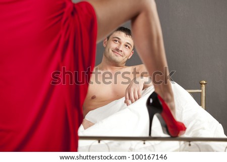 woman in stiletto seducing man in bed