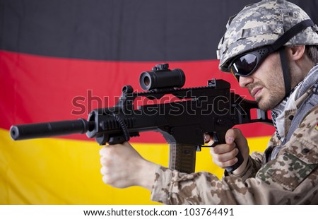 German soldier with machine gun aiming or shooting - german flag in background