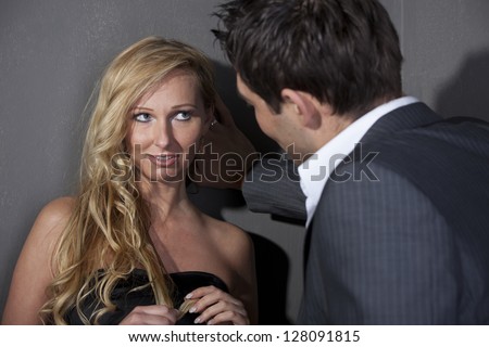 Man flirting with a woman standing at the wall