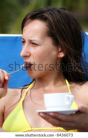 woman sitting in chaise with a spoon in mouth