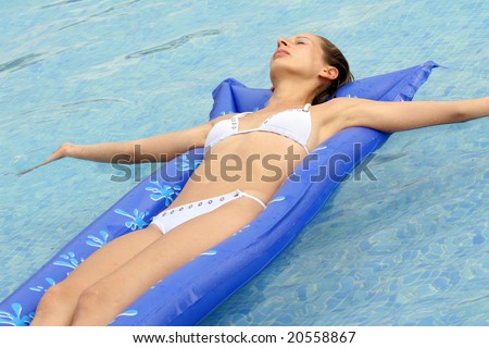 Woman Lying On An Air Mattress In Blue Pool