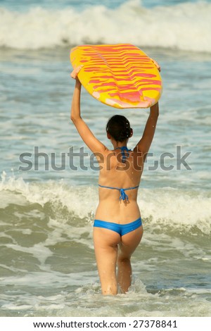 woman holding boogie board in the water