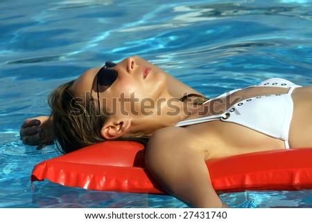 Woman Lying On An Air Mattress In Blue Pool