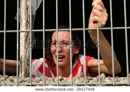 woman behind bars in old prison crying