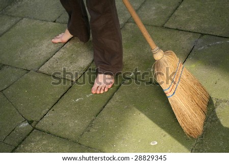 woman sweeping with broomstick outdoor