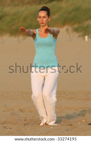 woman doing breathing exercises at the beach