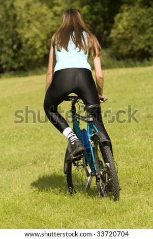 fitness woman biking outdoor, shot from back