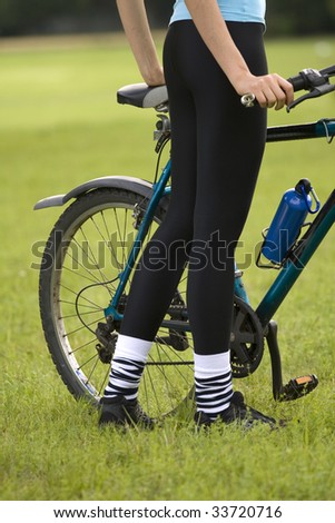 fitness woman with a bike posing outdoor, close up shot of female legs