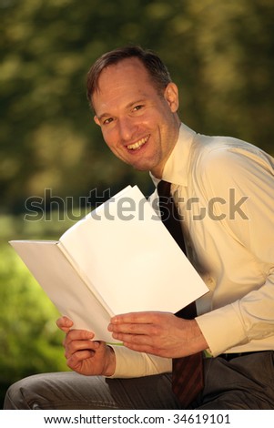 happy businessman reading magazine, blank front cover to place your own message