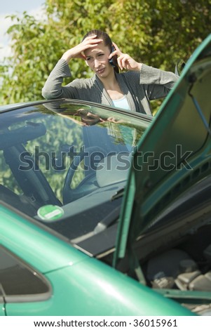 woman with a broken car calling on the cell phone