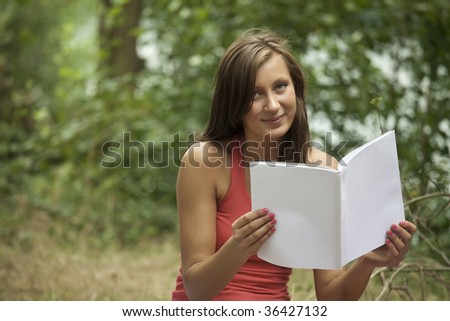 happy young woman with magazine, blank front cover to place your own message