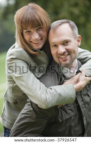 portrait of happy couple, man carrying woman on his back