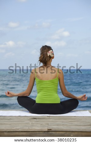 woman sitting in yoga pose on the beach