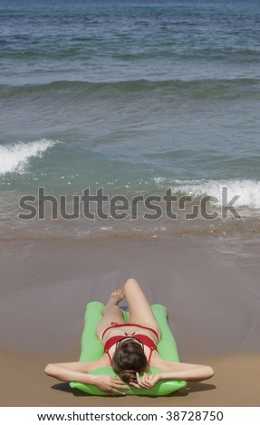 woman on an air mattress relaxing at the beach