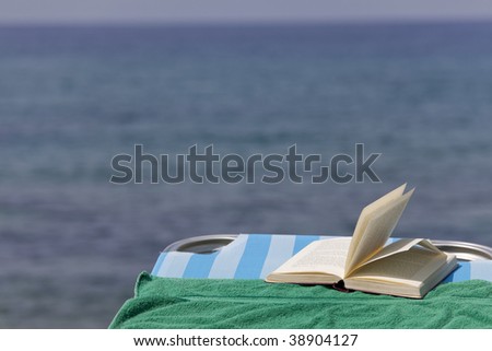 book on the chaise, ocean in the background