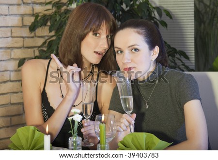 two happy female friends discussing in a restaurant