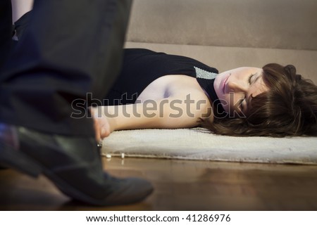 crime scene - unconscious woman lying on the ground, male shoe in foreground