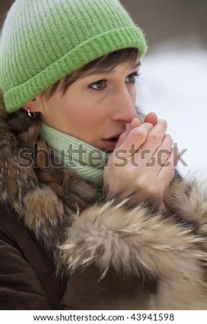 woman warms up her hands with a breath outdoor