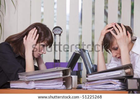 two frustrated businesswomen by work in the office