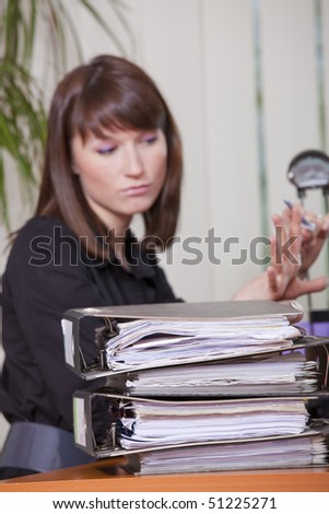 female secretary filing her fingernails by office work - focus on document folders